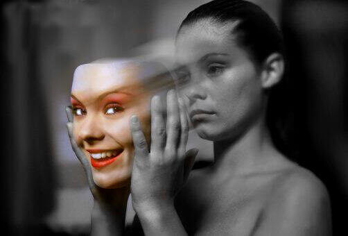 A woman taking off a mask that represents fake emotions and showing her true face