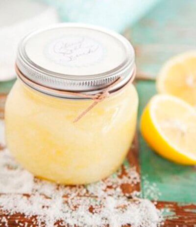 Homemade deodorant in a jar next to a slice of lemon