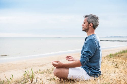 Mand mediterer ved hav for at opretholde et sundt hjerte