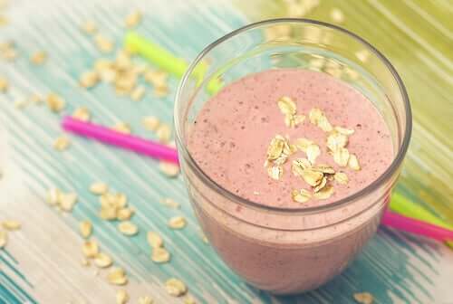 A pink smoothie with oatmeal sprinkled on top.