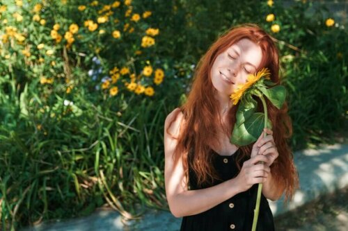 A woman holding a sunflower.