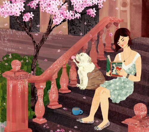 A woman sitting on some steps reading.