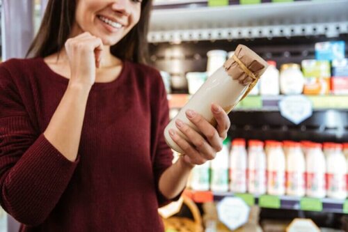 A woman looking at a jar of dairy.