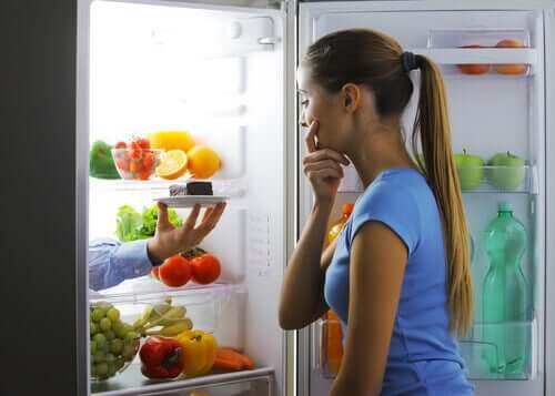 Vrouw kijkt in de koelkast