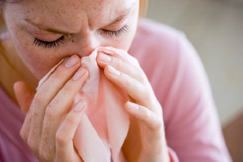 Woman with a cold blowing her nose