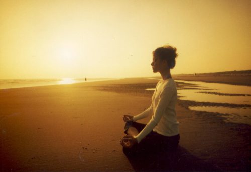 Woman meditating in a beach