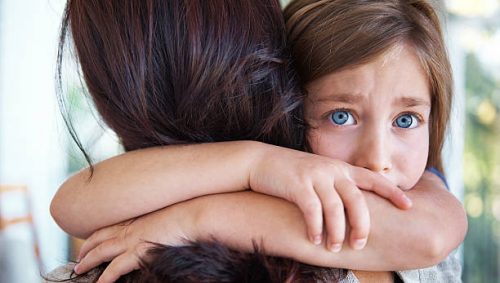 child hugging her mom, demonstrating childhood attachment