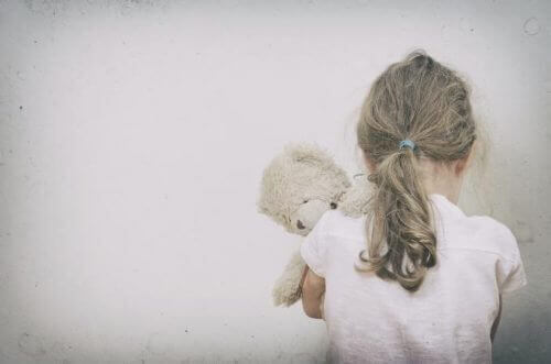 a lonely child hugging a teddy bear