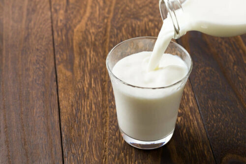 pouring milk into a glass on a wooden table