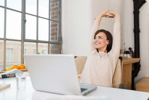 woman stretching whilst on the laptop