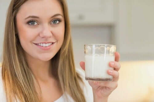 A woman holding a glass of soursop juice.