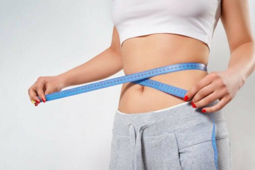 A woman measuring her waist.