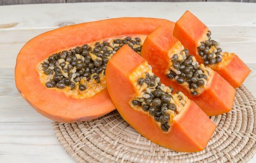 Some cut up papaya on a mat.