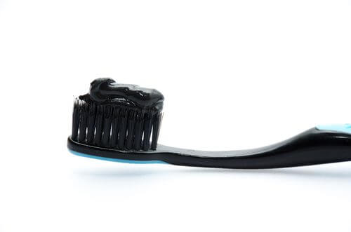A toothbrush with black toothpaste.