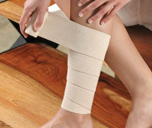 Woman wraps her leg with a bandage
