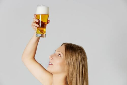 A woman holding a glass of beer.