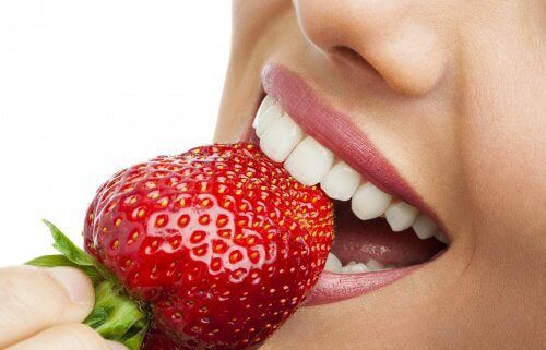 Woman biting into a strawberry