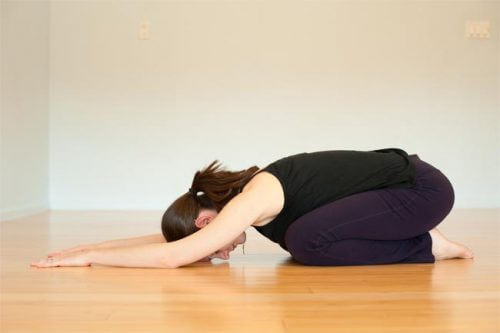 A woman doing the balasana pose.