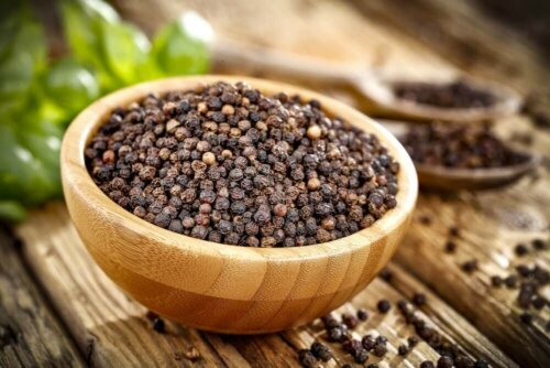Some pepper corns in a wooden bowl.