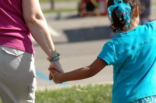A child holding an adult's hand.