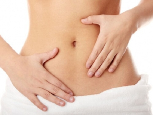 benefits of eating pumpkins: lose weight A woman holding her flat stomach.