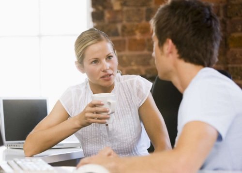 Blond woman and brunet man having coffee at work paid leave painful periods