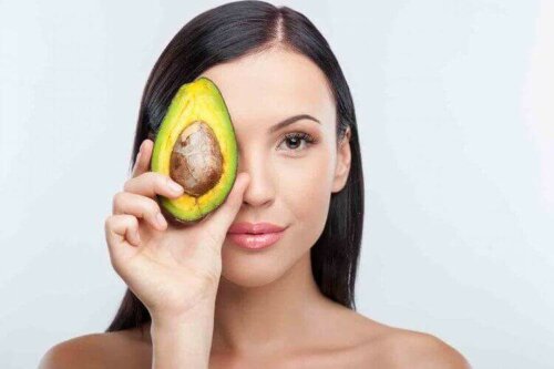 A woman holding up an avocado.