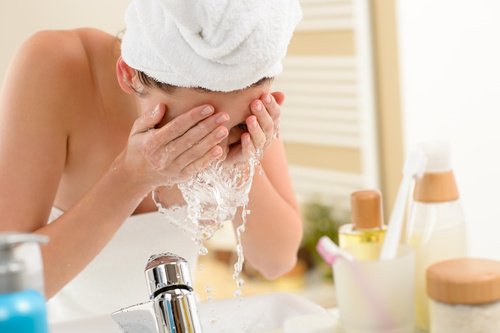 A woman washing her face.