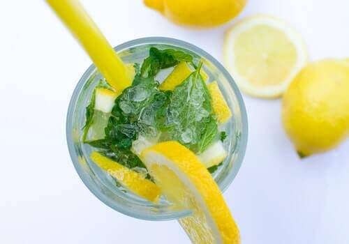 A glass with some mint and lemon water.