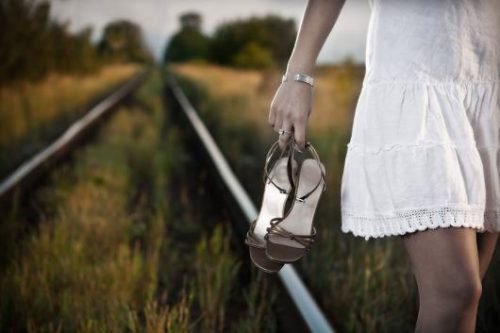 Woman walking along railroad track