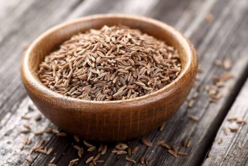 Some cumin seeds in a wooden bowl.