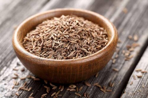 Some cumin seeds in a wooden bowl.