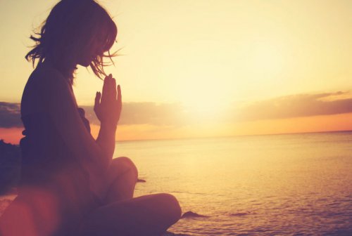 Woman meditating in the beach