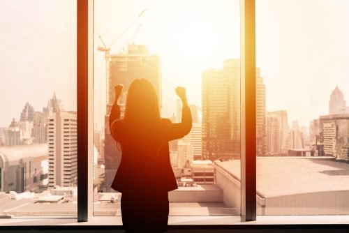 Woman watching sunrise from office