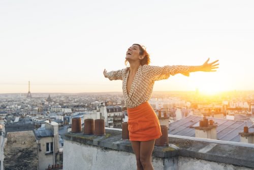 Happy woman with arms spread on roof