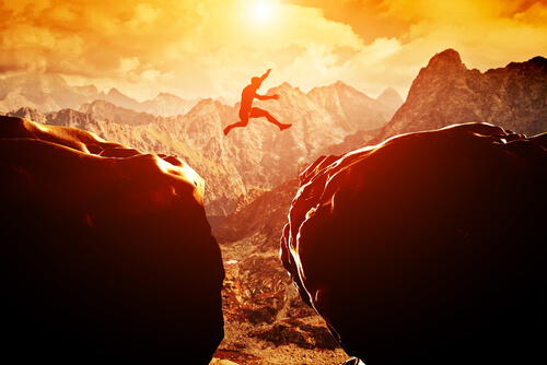 Man jumping between cliffs