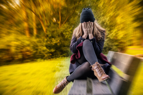 Woman with anxiety on bench in park