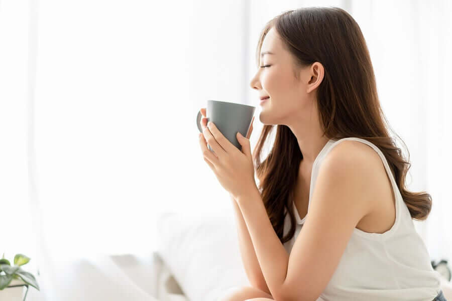 A woman drinking a cup of passionflower tea.