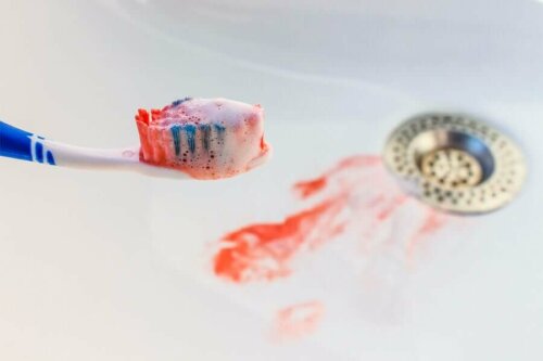 A bloody toothbrush in a sink.