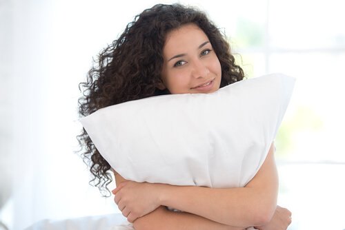 woman holding a pillow to reduce neck pain