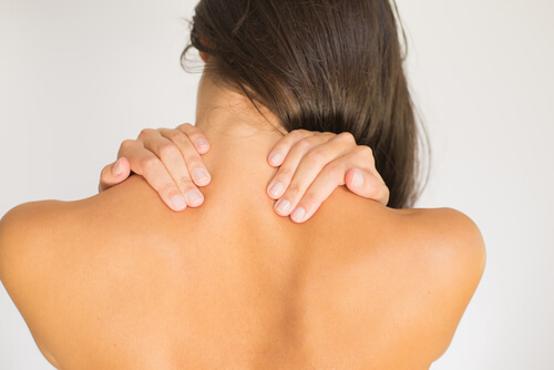 woman stretching her neck to reduce neck pain