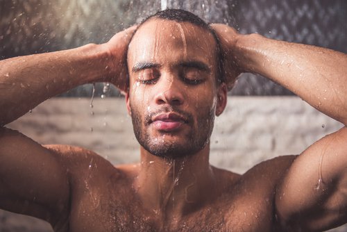 man taking a shower to reduce neck pain