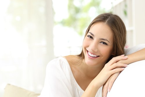A woman smiling with healthy skin from ginger and carrot juice.