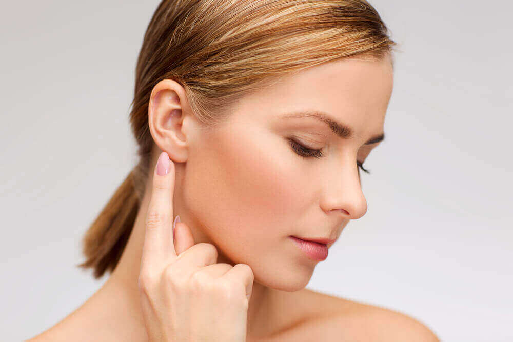 A woman pointing to her ear.