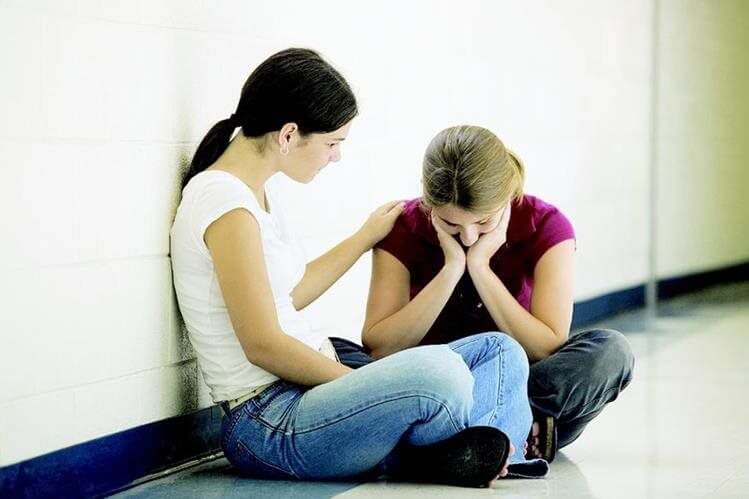 sad girl and consoling friends in the hallway working on mental balance