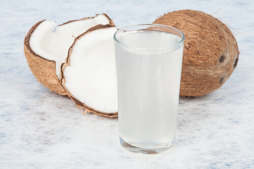 A cut coconut and glass of coconut milk.