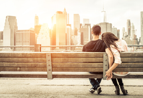 A couple sitting on a bench.