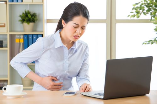 woman in pain at her computer