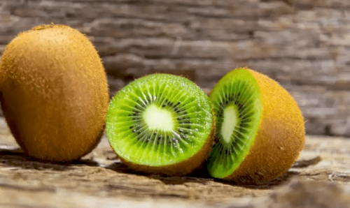 A couple kiwis on a board.
