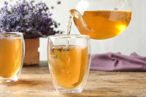 A person pouring tea in a glass.